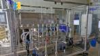 Complete filling line with Tecman Nelpas Tecnoenvase Tudela bottle filling, labeling, capping, and positioning machines for cosmetic liquids.