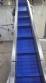 Inova Industrial inclined stainless steel conveyor belt with cleats.