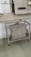 Label applicator machine with steam-operated shrink tunnel for sleeves.