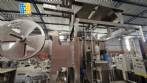 Labeling machine with steam sleeve tunnel and bottle baler
